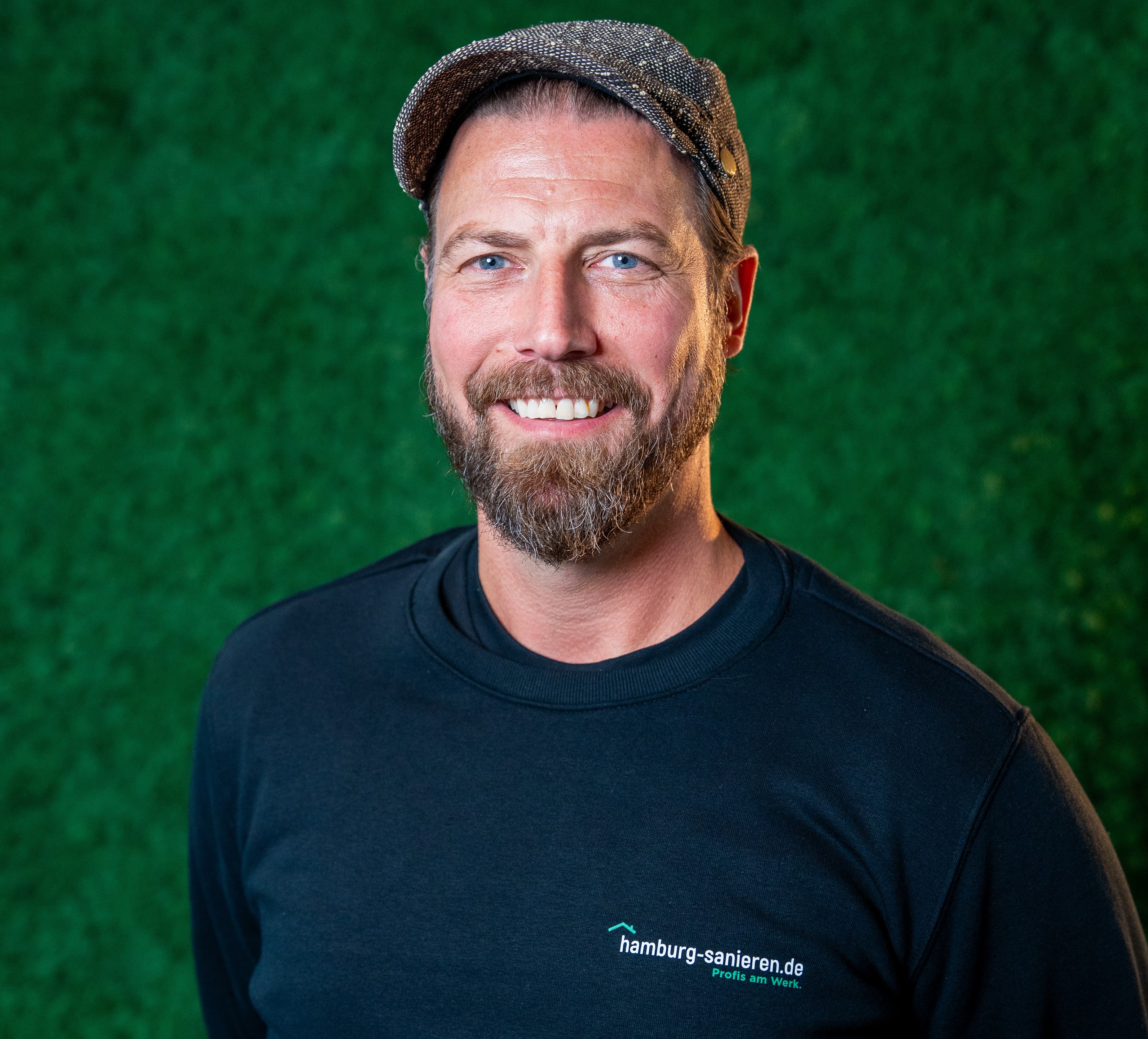 Transporter von hamburg-sanieren.de vor einem Haus, bereit für Sanierungsarbeiten, umgeben von Bäumen und Baustellenmaterial.